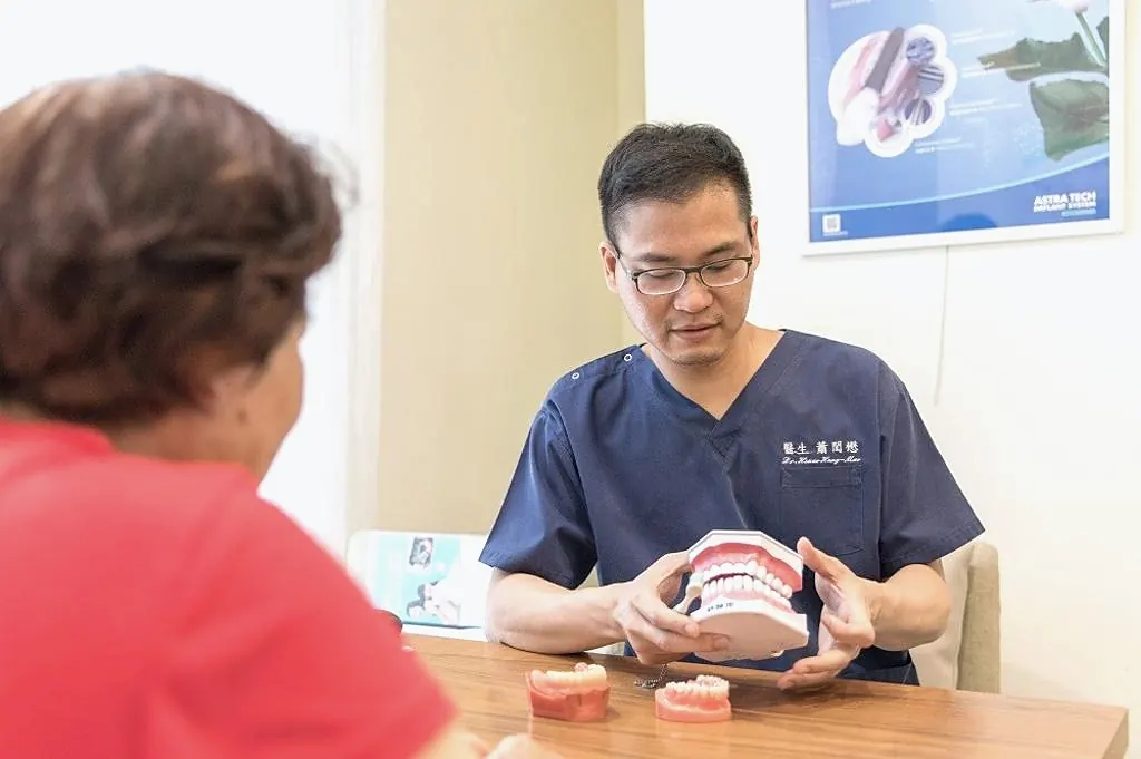 蕭醫師在診間用牙模為患者解說